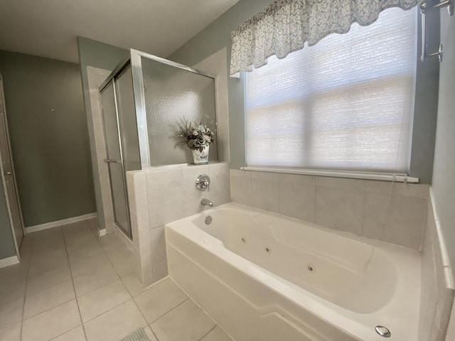 bathroom featuring baseboards, a jetted tub, a stall shower, and tile patterned flooring