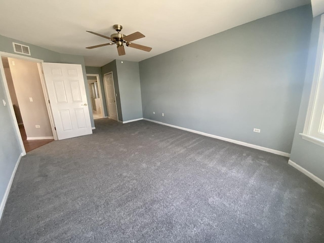 unfurnished bedroom featuring dark colored carpet, visible vents, baseboards, and ceiling fan