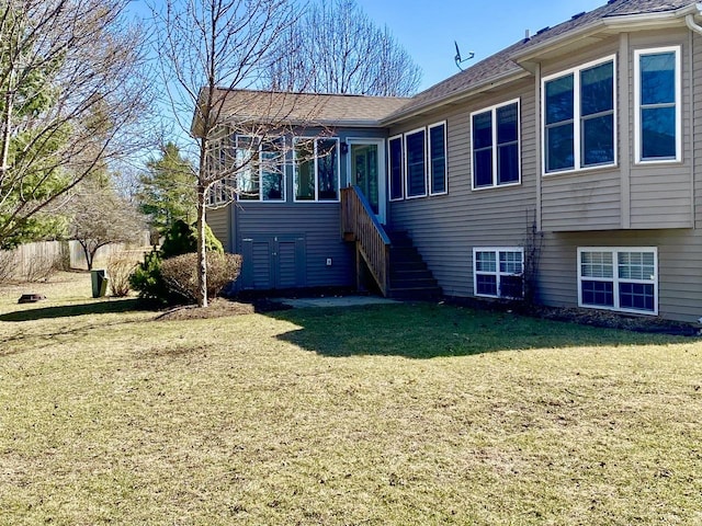 rear view of property featuring stairway, a yard, and a sunroom