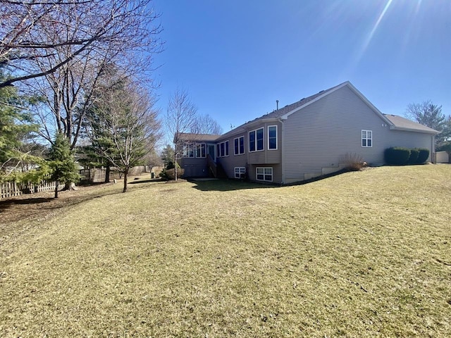 back of property featuring a yard and fence