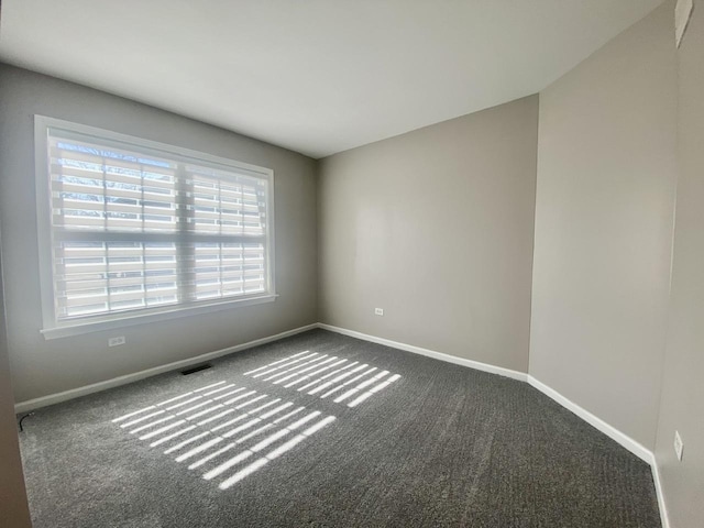 empty room with carpet flooring, baseboards, and visible vents