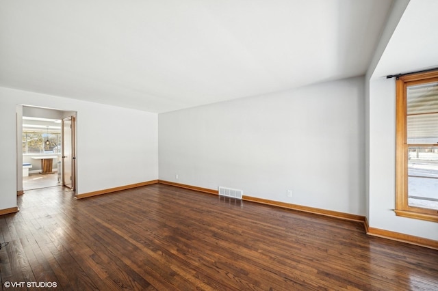 unfurnished room with dark hardwood / wood-style flooring