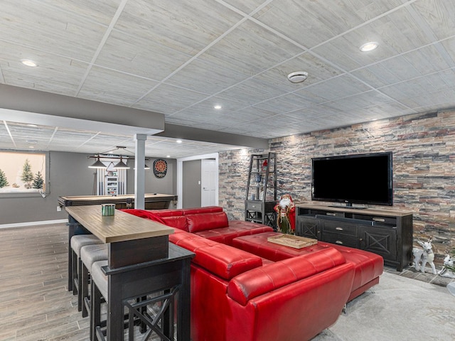 living area featuring a bar, recessed lighting, wood finished floors, and baseboards