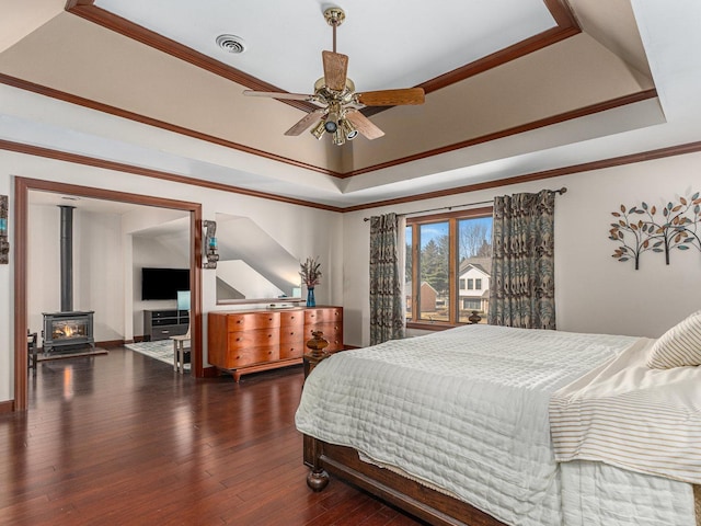 bedroom featuring a raised ceiling, visible vents, crown molding, and hardwood / wood-style flooring