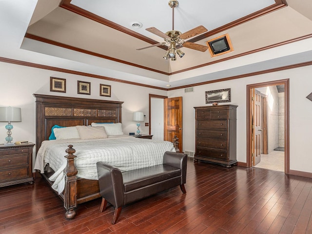 bedroom featuring a raised ceiling, visible vents, crown molding, and wood finished floors