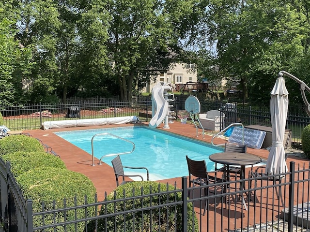 view of swimming pool featuring a fenced in pool, fence, and a water slide