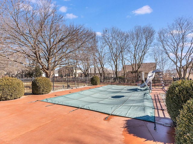 view of swimming pool featuring a fenced in pool, a water slide, fence, and a patio