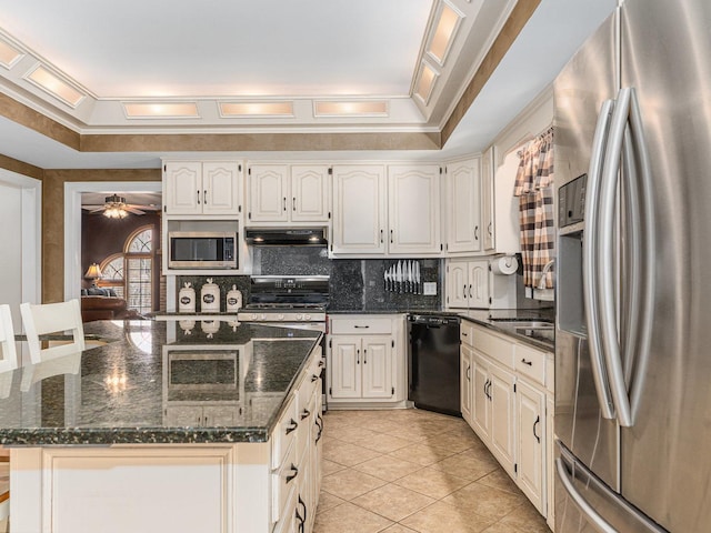 kitchen with crown molding, stainless steel appliances, decorative backsplash, dark stone counters, and under cabinet range hood