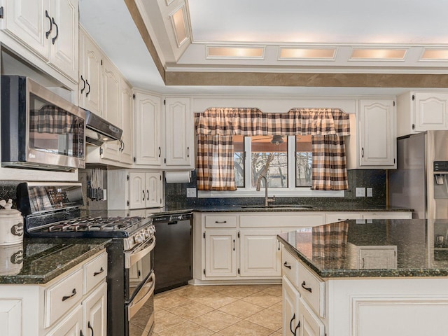 kitchen featuring stainless steel appliances, decorative backsplash, a sink, dark stone countertops, and under cabinet range hood