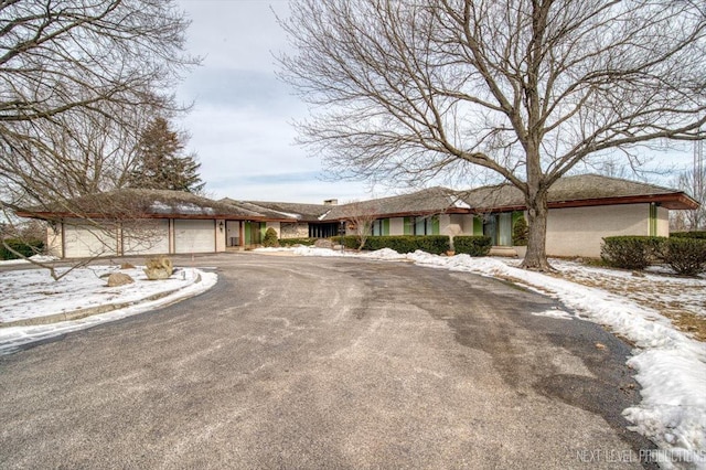 view of front facade featuring an attached garage and aphalt driveway