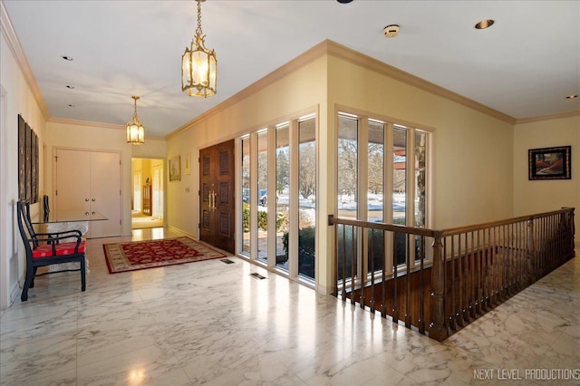 foyer entrance with a notable chandelier, marble finish floor, recessed lighting, and crown molding