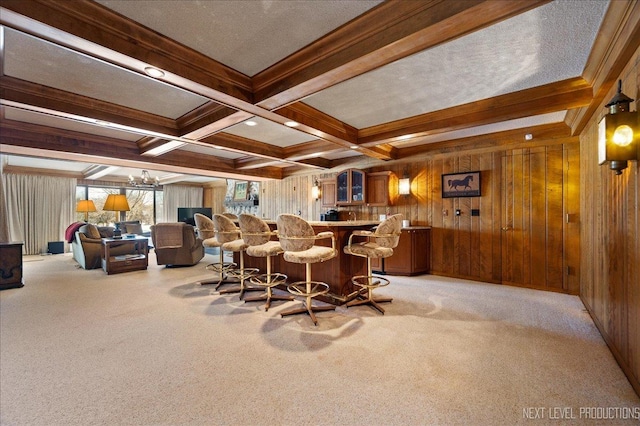 bar with beamed ceiling, indoor wet bar, and light colored carpet