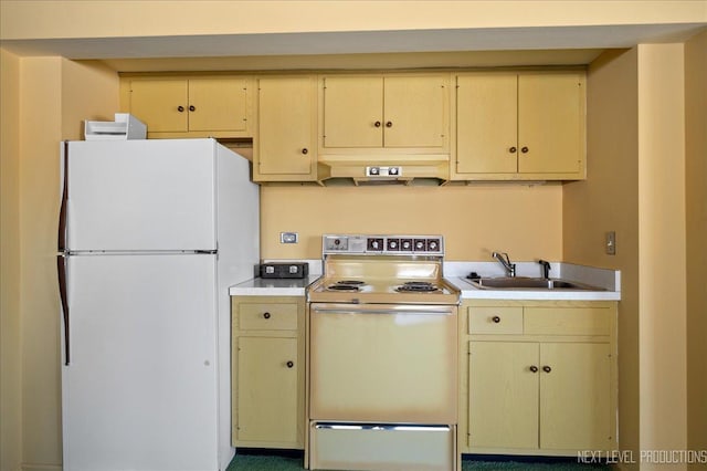 kitchen featuring cream cabinetry, light countertops, a sink, white appliances, and under cabinet range hood