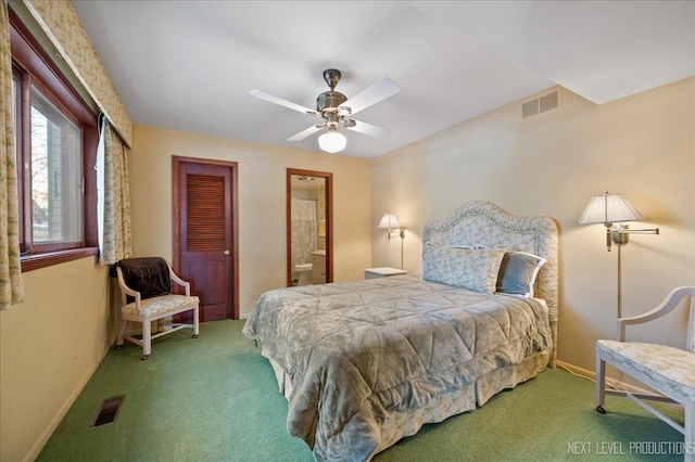 bedroom featuring ensuite bathroom, carpet flooring, visible vents, and baseboards