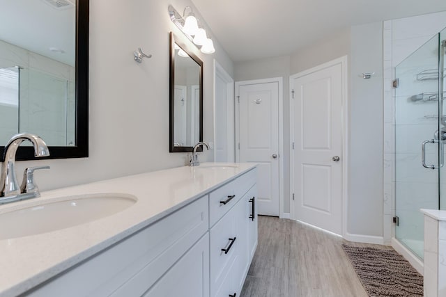 bathroom with walk in shower, vanity, and hardwood / wood-style flooring