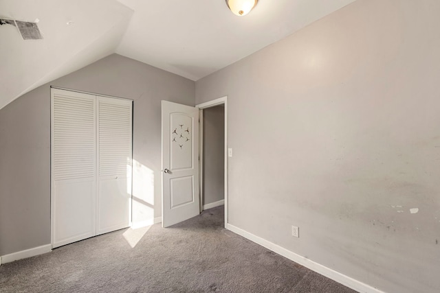 unfurnished bedroom featuring carpet floors, a closet, and vaulted ceiling