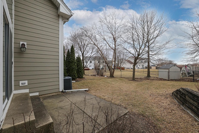 view of yard with central AC unit, a shed, and a patio area