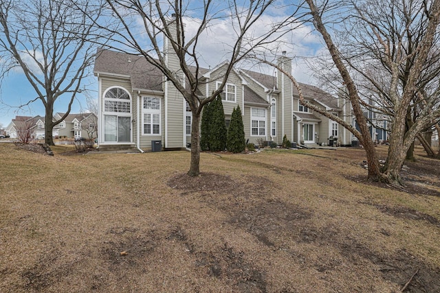 front facade with central AC unit and a front yard