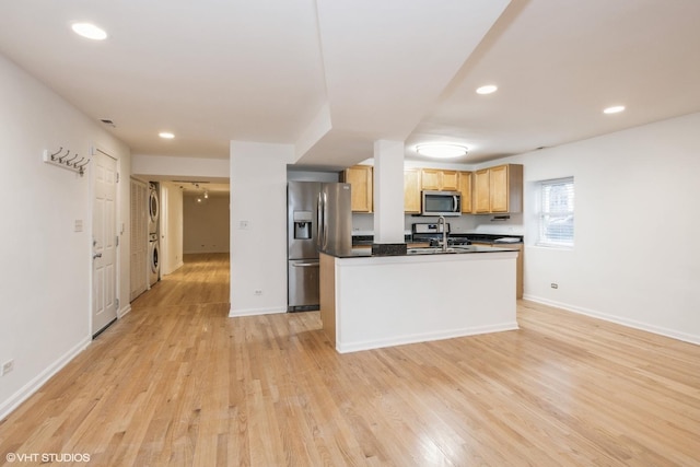 kitchen with sink, light hardwood / wood-style flooring, stainless steel appliances, and a center island