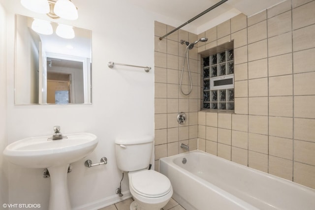 bathroom with tiled shower / bath, tile patterned floors, and toilet