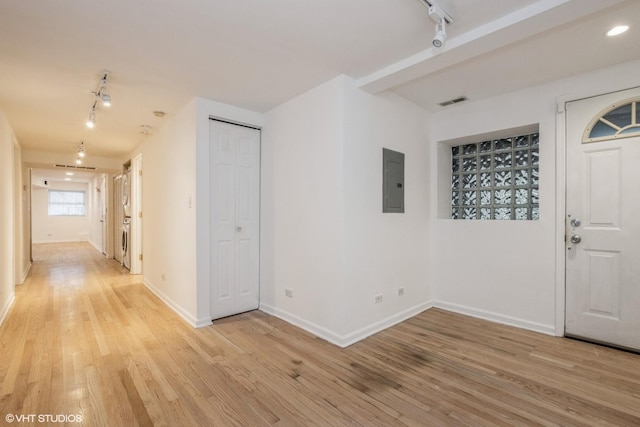 foyer entrance featuring track lighting, washer / clothes dryer, electric panel, and light hardwood / wood-style flooring