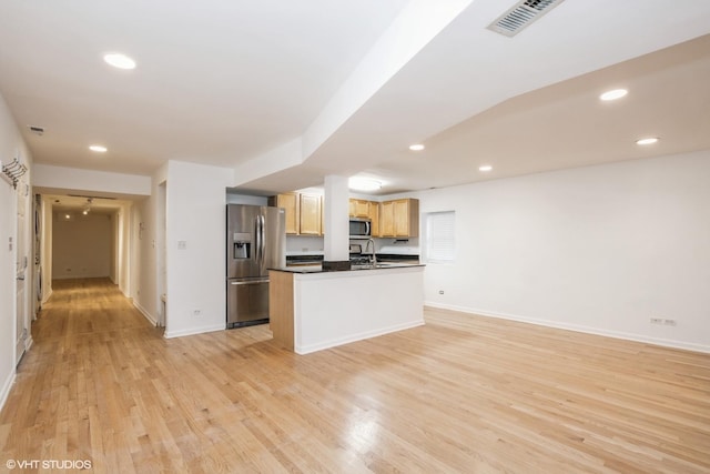 kitchen featuring a kitchen island, sink, light hardwood / wood-style floors, stainless steel appliances, and light brown cabinets