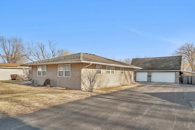 ranch-style house featuring a garage and an outbuilding