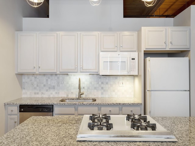 kitchen with white cabinetry, sink, backsplash, and white appliances