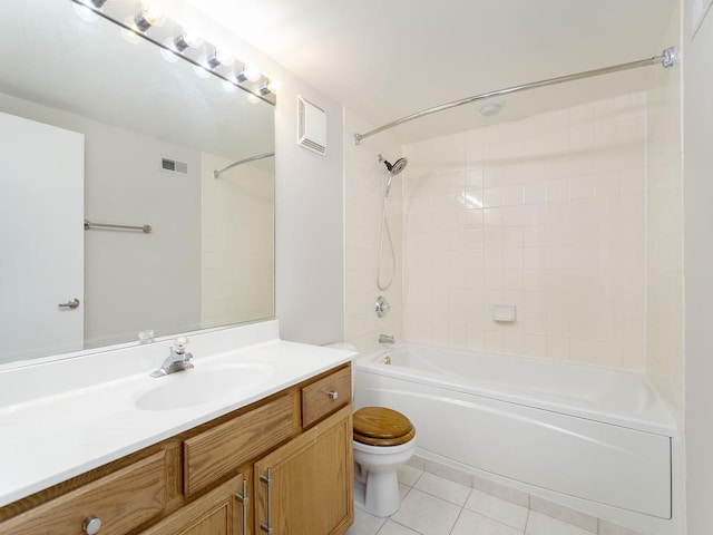 full bathroom featuring tile patterned flooring, vanity, tiled shower / bath combo, and toilet