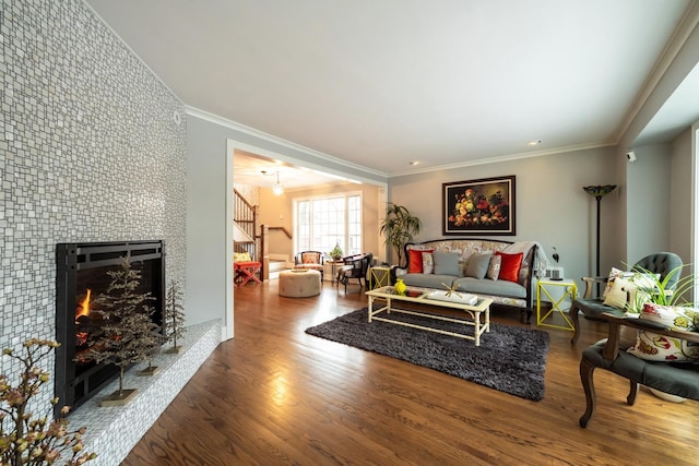 living room featuring hardwood / wood-style floors, a fireplace, and ornamental molding