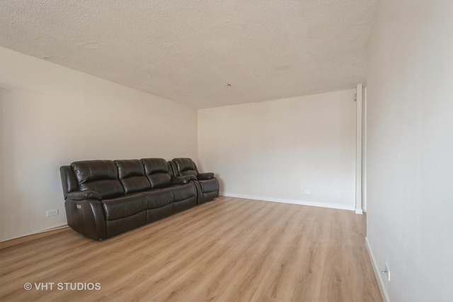 living room with a textured ceiling and light hardwood / wood-style floors