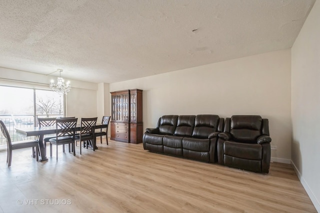 living room featuring a textured ceiling, light hardwood / wood-style flooring, and a chandelier