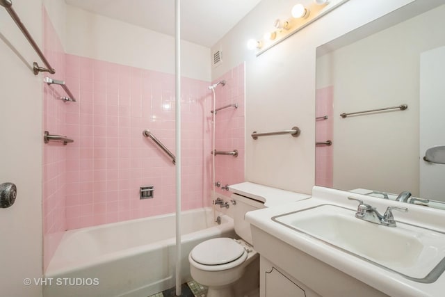 full bathroom featuring tiled shower / bath combo, vanity, and toilet