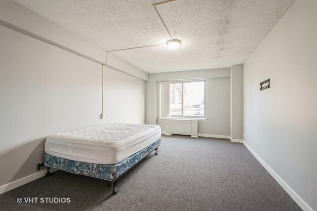 bedroom with radiator heating unit, a textured ceiling, and carpet