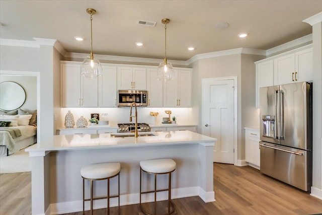 kitchen with white cabinetry, stainless steel appliances, and hanging light fixtures