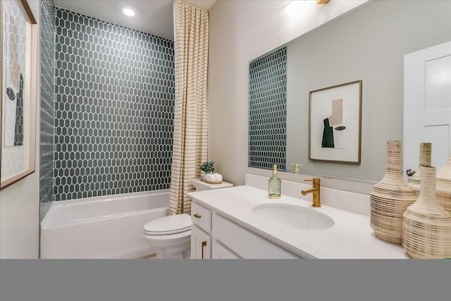 full bathroom featuring tiled shower / bath, vanity, and toilet