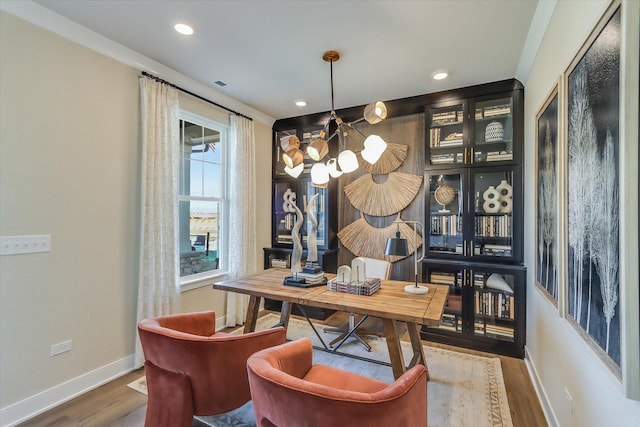 home office featuring wood-type flooring and an inviting chandelier