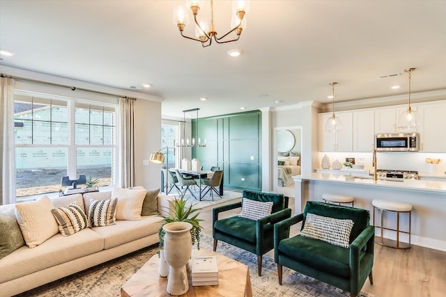 living room with crown molding, light hardwood / wood-style floors, and a chandelier