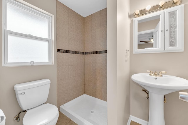 bathroom featuring sink, toilet, and tiled shower