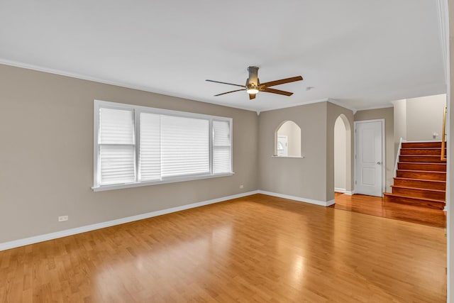 spare room with crown molding, light wood-type flooring, and ceiling fan