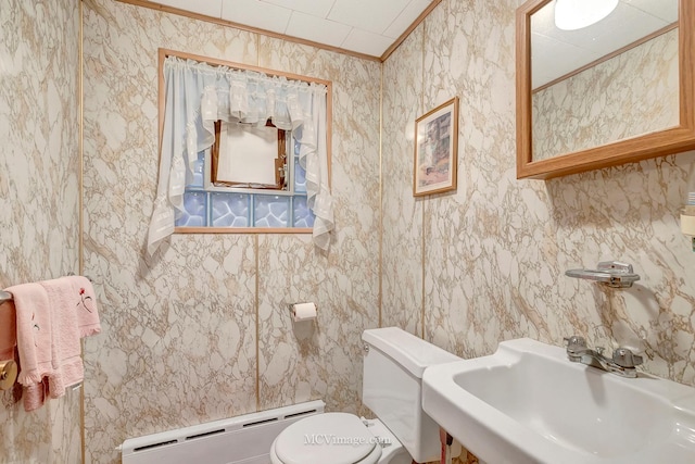 bathroom with a baseboard radiator, ornamental molding, toilet, and sink