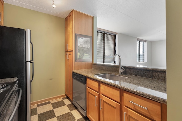 kitchen featuring sink, dark stone counters, and appliances with stainless steel finishes