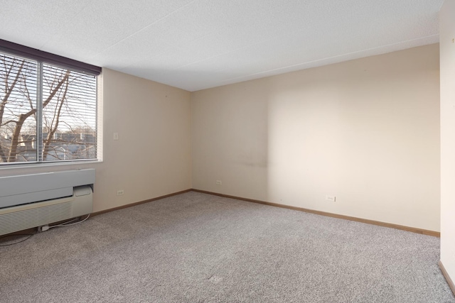 unfurnished room featuring a wall mounted AC, a textured ceiling, and carpet