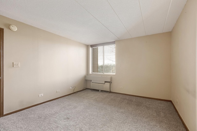 carpeted empty room featuring a textured ceiling