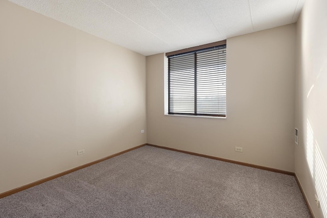 carpeted empty room featuring a textured ceiling