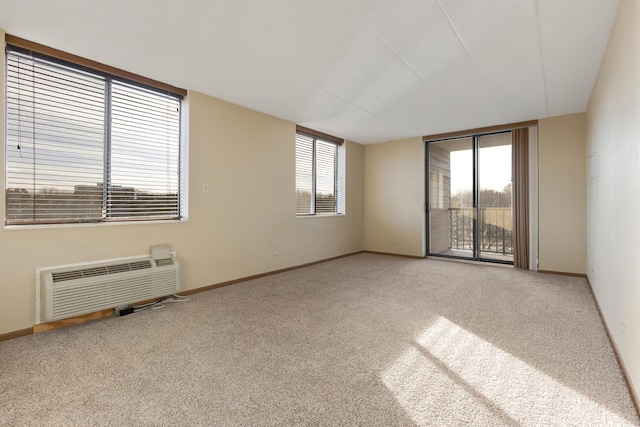 carpeted spare room with a wall unit AC