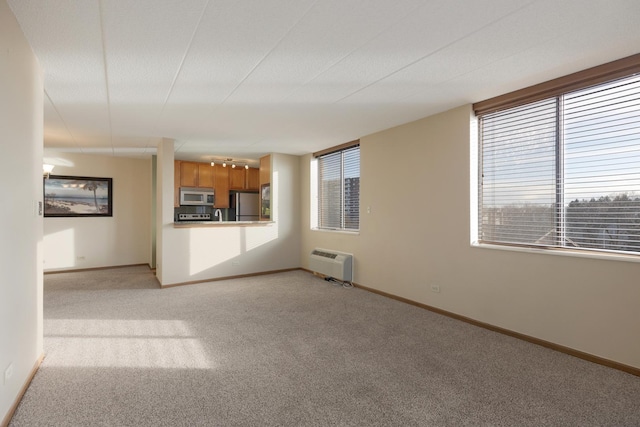 unfurnished living room featuring light colored carpet and a wall unit AC