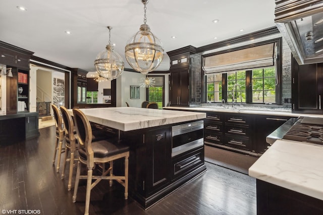 kitchen with a center island, sink, dark hardwood / wood-style floors, and decorative light fixtures