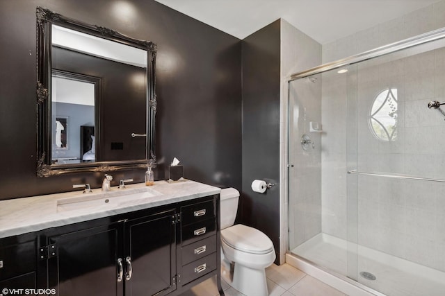 bathroom with tile patterned flooring, vanity, an enclosed shower, and toilet