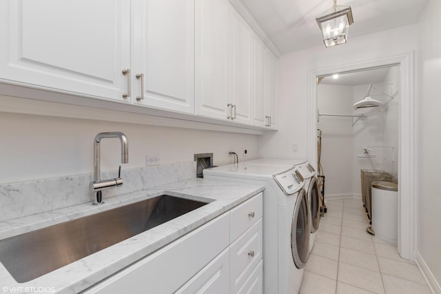 laundry area with separate washer and dryer, sink, light tile patterned floors, and cabinets